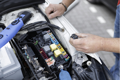 Open car bonnet with technician repairing module